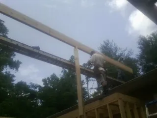 Carpenter setting a ridge beam over a new addition frame — Ice Dam Removal by Roofing Brothers in Winnsboro