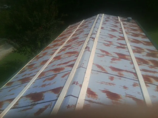 Rusted metal roof panels with new wood purlins before replacement — Storm Damage Roof Repair in Winnsboro by Roofing Brothers